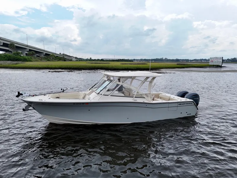 Slide: The Image of 2022 Grady-White Freedom 307 boat on water near a bridge, under cloudy sky. - 23