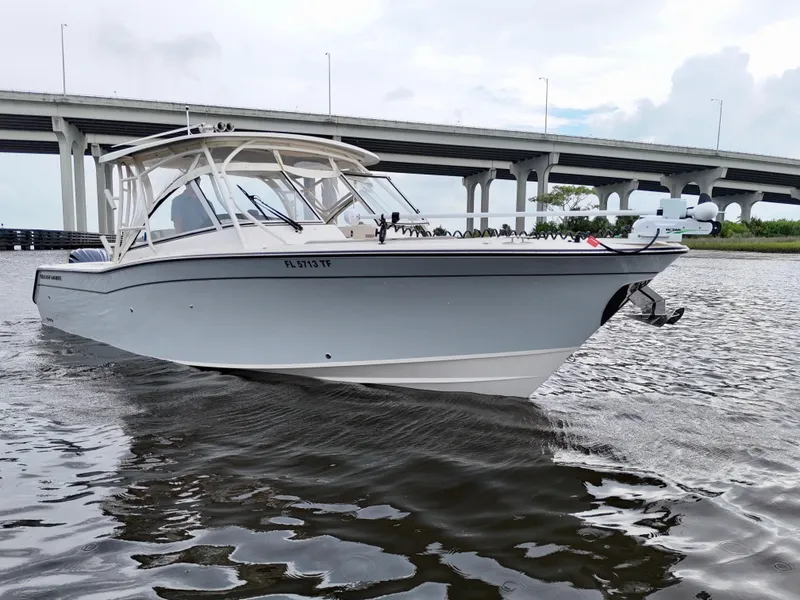 Slide: The Image of 2022 Grady-White Freedom 307 boat cruising under a bridge on a cloudy day. - 31