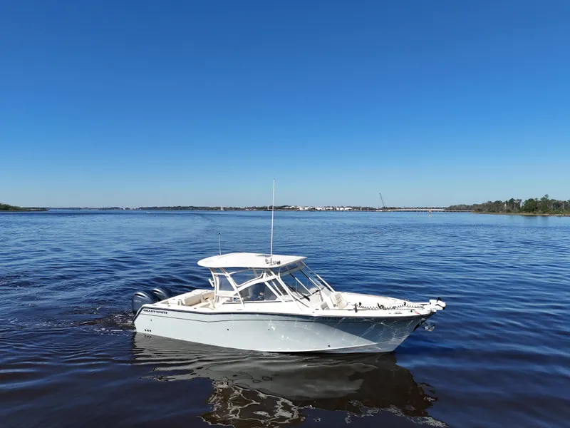 Slide: The Image of 2022 Grady-White Freedom 307 boat on calm blue water under clear sky. - 33