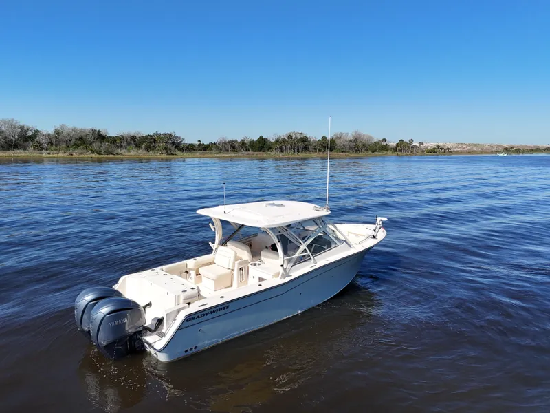 Slide: The Image of 2022 Grady-White Freedom 307 boat on calm water under clear blue sky. - 35