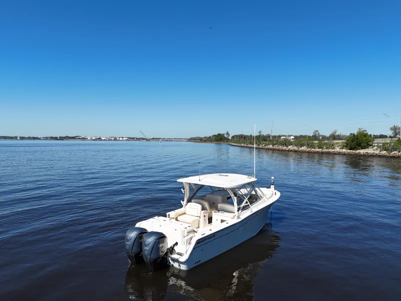 Slide: The Image of 2022 Grady-White Freedom 307 boat on calm water under clear blue sky. - 37