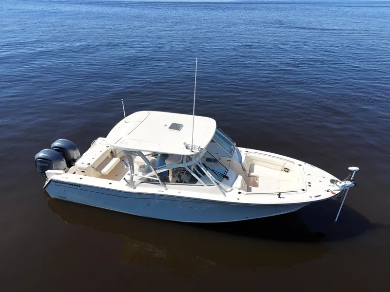 Slide: The Image of 2022 Grady-White Freedom 307 boat on calm water, featuring dual outboard engines. - 39