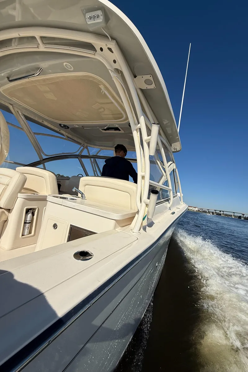 Slide: The Image of 2022 Grady-White Freedom 307 boat cruising on open water under clear blue sky. - 42