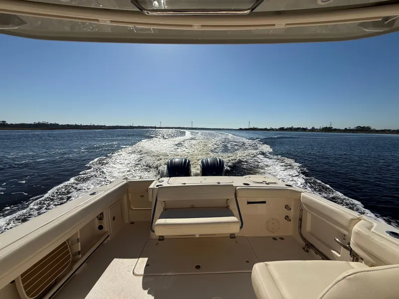 Slide: The Image of 2022 Grady-White Freedom 307 boat cruising on open water, rear view. - 46