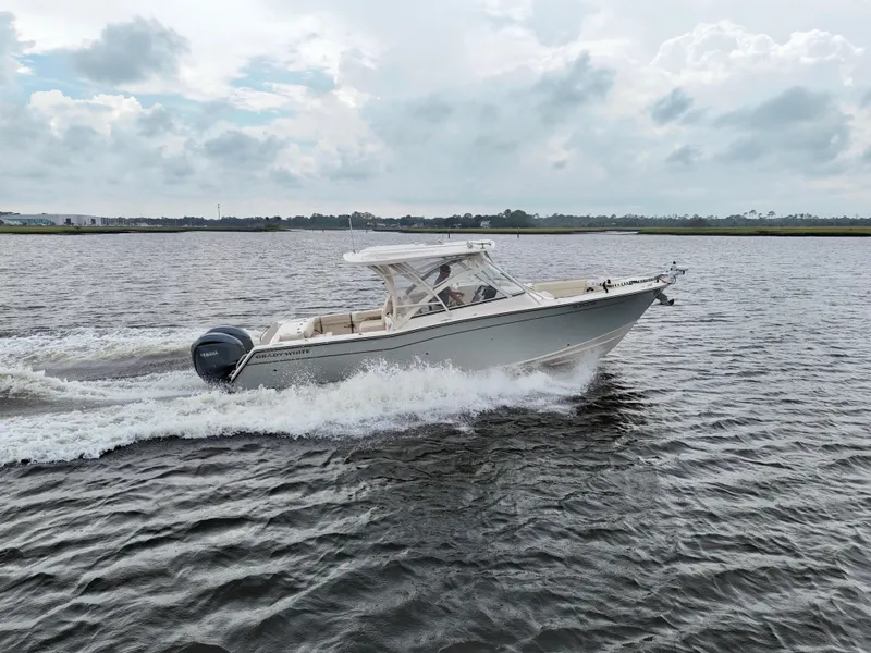 Slide: The Image of 2022 Grady-White Freedom 307 boat cruising on open water under cloudy skies. - 5