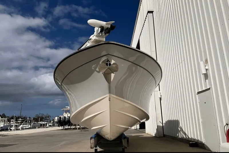 Slide: The Image of 2022 Grady-White Freedom 307 boat docked near a large building under a blue sky. - 50
