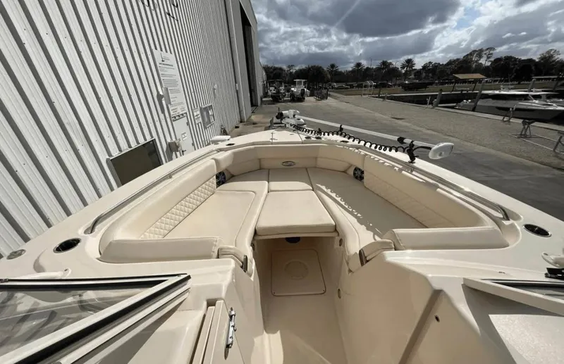 Slide: The Image of 2022 Grady-White Freedom 307 boat, spacious seating, docked near a marina under cloudy skies. - 55