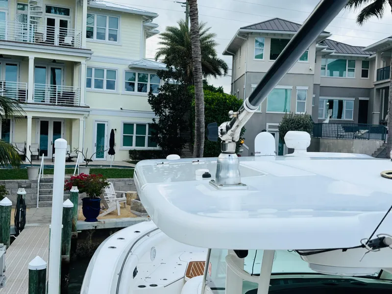 Slide: The Image of Boston Whaler 370 Outrage 2016 near waterfront homes and palm trees. - 11
