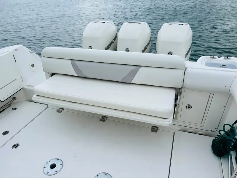 Slide: The Image of 2016 Boston Whaler 370 Outrage boat with triple Mercury engines, featuring a foldable rear seat. - 21