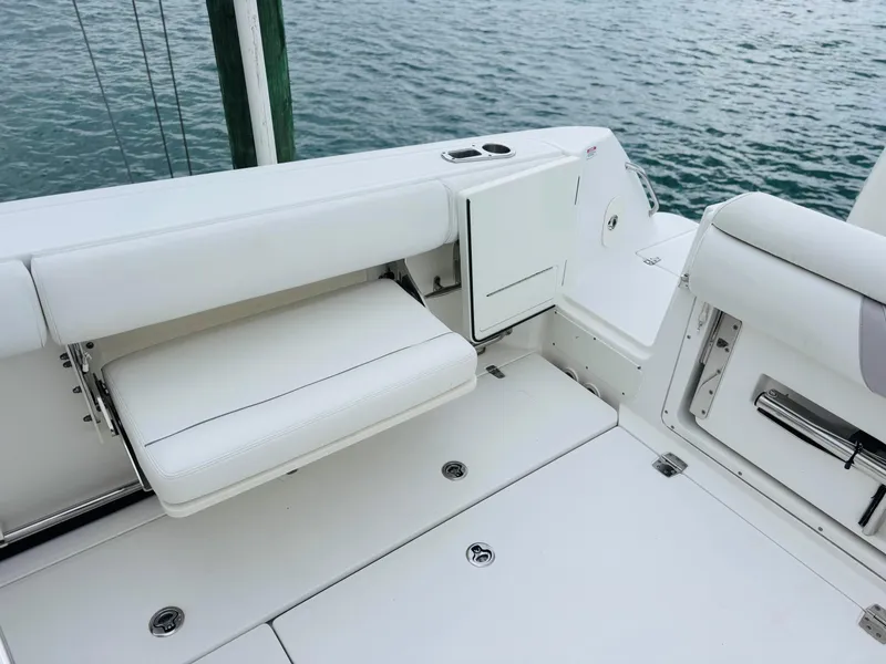 Slide: The Image of 2016 Boston Whaler 370 Outrage boat interior with white seating and storage compartments. - 27