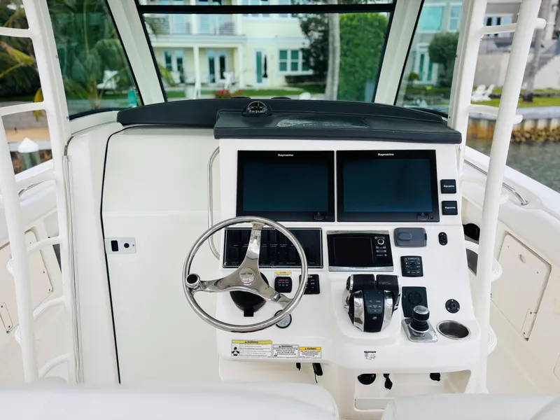 Slide: The Image of 2016 Boston Whaler 370 Outrage helm with dual screens and steering wheel. - 29