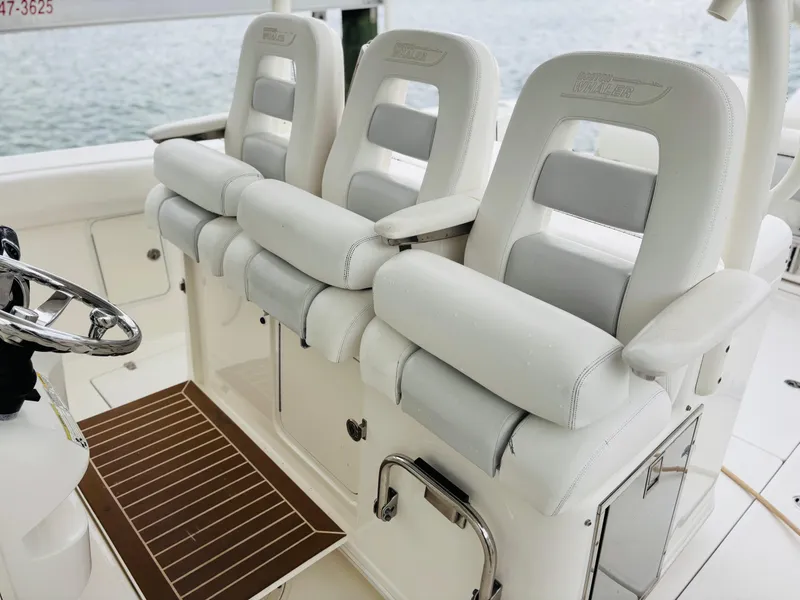 Slide: The Image of 2016 Boston Whaler 370 Outrage helm seats, white upholstery, sleek design, luxury boating interior. - 36