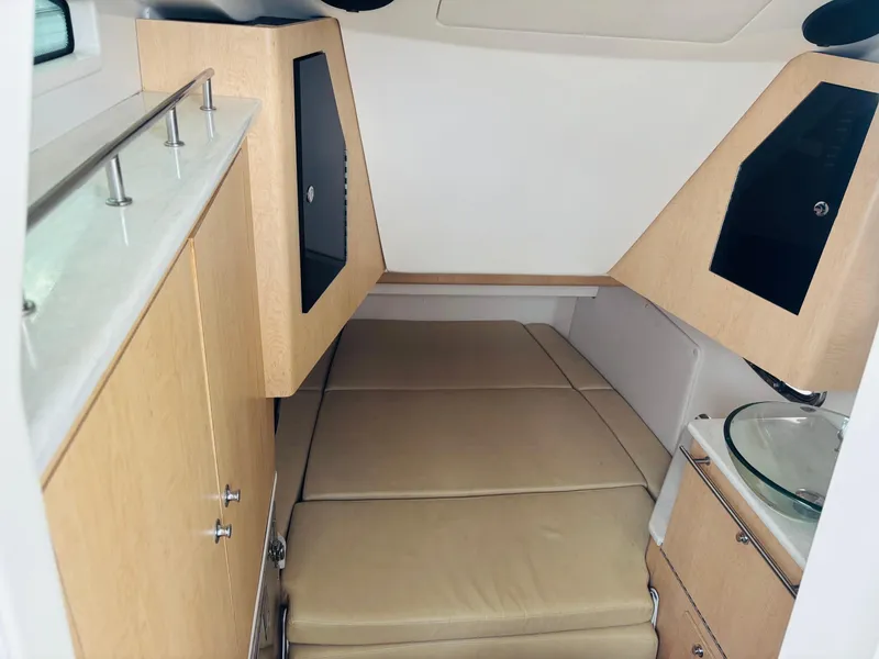Slide: The Image of 2016 Boston Whaler 370 Outrage cabin interior with beige seating and modern cabinetry. - 40
