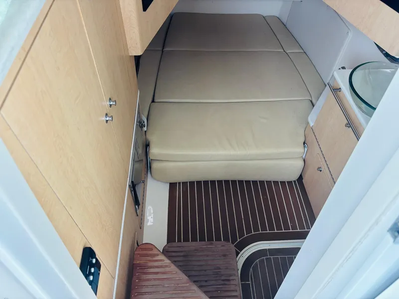 Slide: The Image of 2016 Boston Whaler 370 Outrage cabin interior with beige seating and wooden flooring. - 41