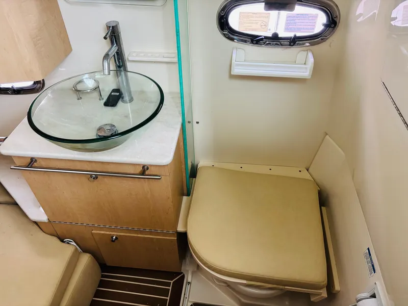Slide: The Image of Interior of 2016 Boston Whaler 370 Outrage, featuring a compact bathroom with sink and toilet. - 43