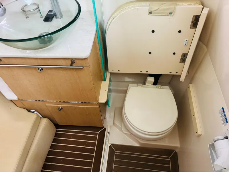 Slide: The Image of 2016 Boston Whaler 370 Outrage boat bathroom with toilet and glass sink. - 44