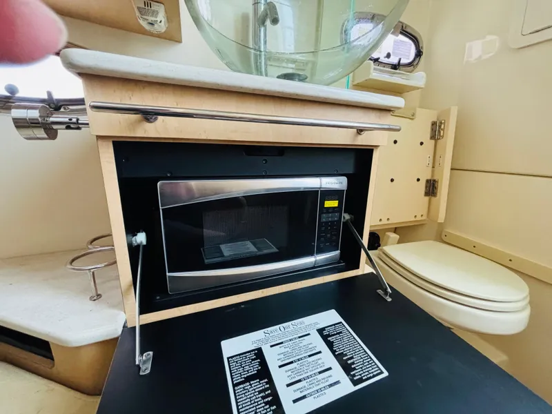 Slide: The Image of 2016 Boston Whaler 370 Outrage interior with microwave and compact bathroom setup. - 47
