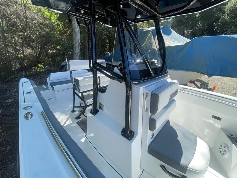 Slide: The Image of 2019 Blackfin 212 CC boat interior with seating and console, parked outdoors. - 10