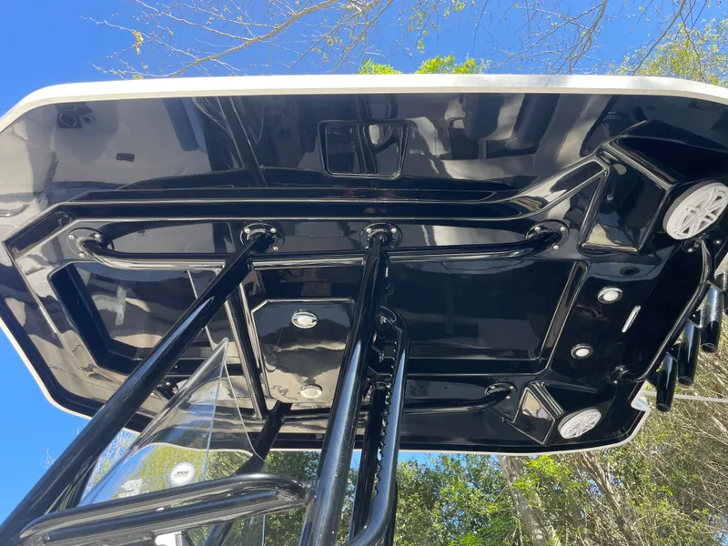 Slide: The Image of 2019 Blackfin 212 CC boat's sleek black T-top against a clear blue sky. - 13