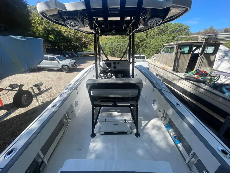 Slide: The Image of 2019 Blackfin 212 CC boat interior with seating and console, parked outdoors. - 14