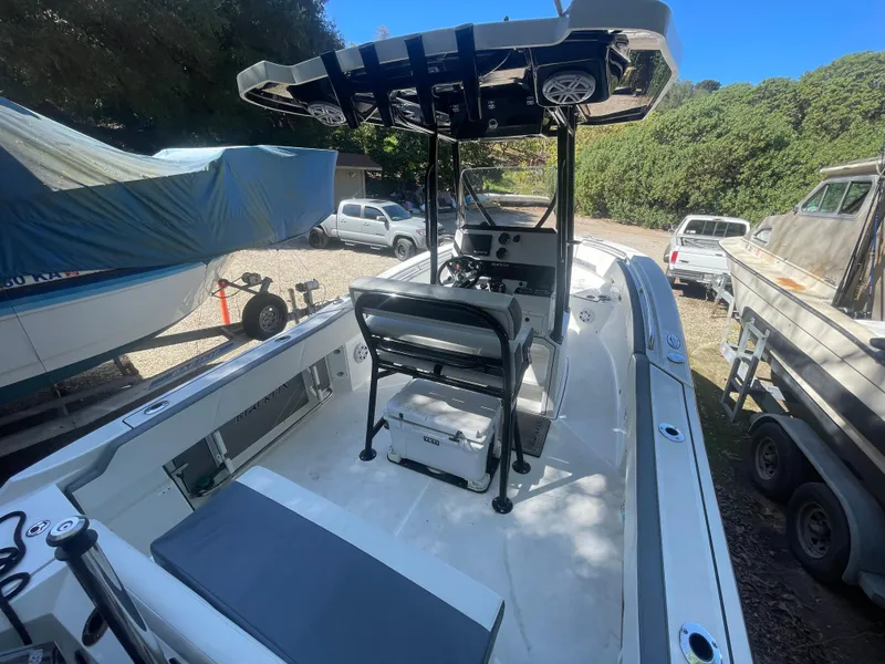 Slide: The Image of 2019 Blackfin 212 CC boat with center console, parked outdoors, surrounded by trees and vehicles. - 5