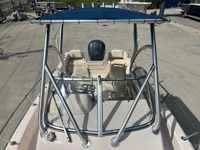 Slide: The Image of 2007 Grady-White Adventure 208 boat with blue canopy and seating, docked on concrete. - 10