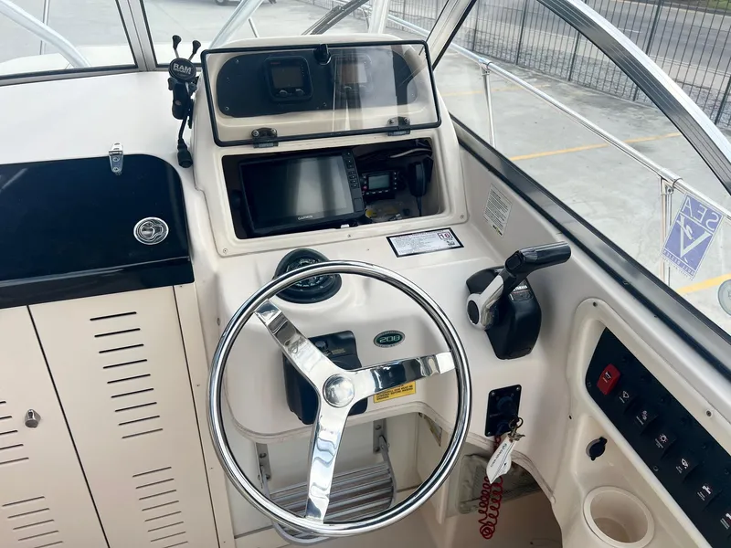 Slide: The Image of 2007 Grady-White Adventure 208 boat dashboard with steering wheel and controls. - 17