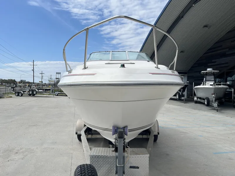 Slide: The Image of 1992 Sea Ray 230 Sundancer boat on trailer, parked outdoors under a partly cloudy sky. - 11