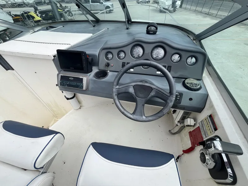 Slide: The Image of 1992 Sea Ray 230 Sundancer cockpit with steering wheel, gauges, and navigation equipment. - 13