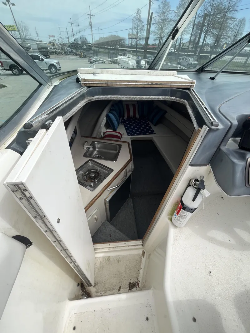 Slide: The Image of Interior view of 1992 Sea Ray 230 Sundancer boat cabin with kitchenette and seating area. - 16
