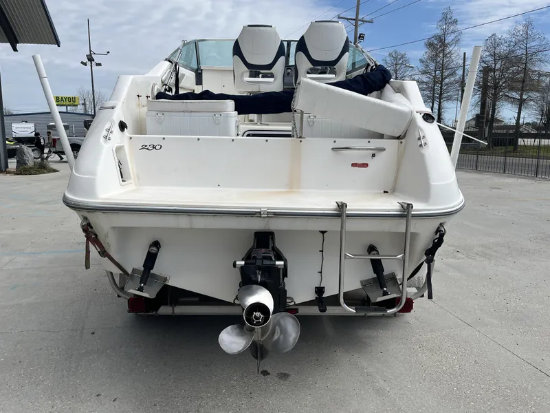 Slide: The Image of 1992 Sea Ray 230 Sundancer boat, rear view, docked on concrete surface. - 5