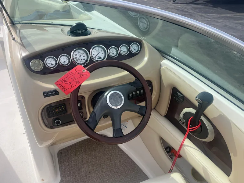 Slide: The Image of 2004 Chaparral Sunesta 254 boat dashboard with steering wheel and control panel. - 11