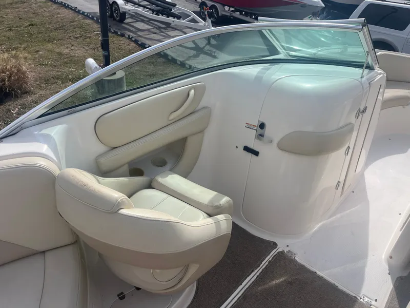Slide: The Image of 2004 Chaparral Sunesta 254 boat interior with beige seating and windshield. - 12