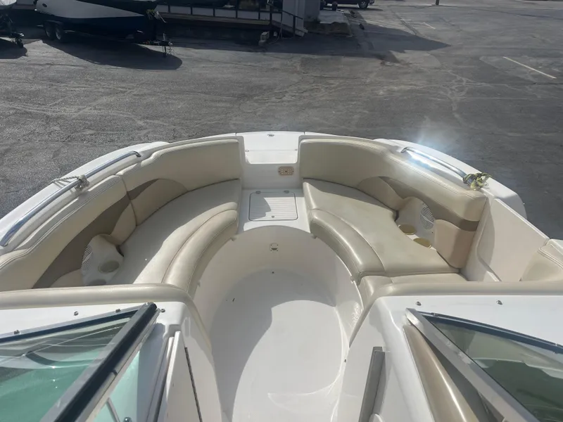 Slide: The Image of 2004 Chaparral Sunesta 254 boat interior with beige seating and cup holders. - 7