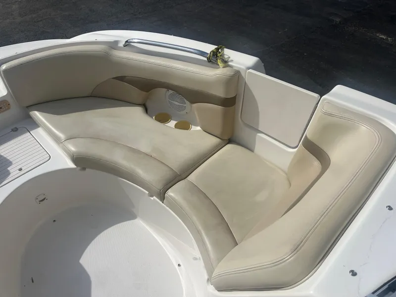 Slide: The Image of 2004 Chaparral Sunesta 254 boat seating area with beige cushions and cup holders. - 9