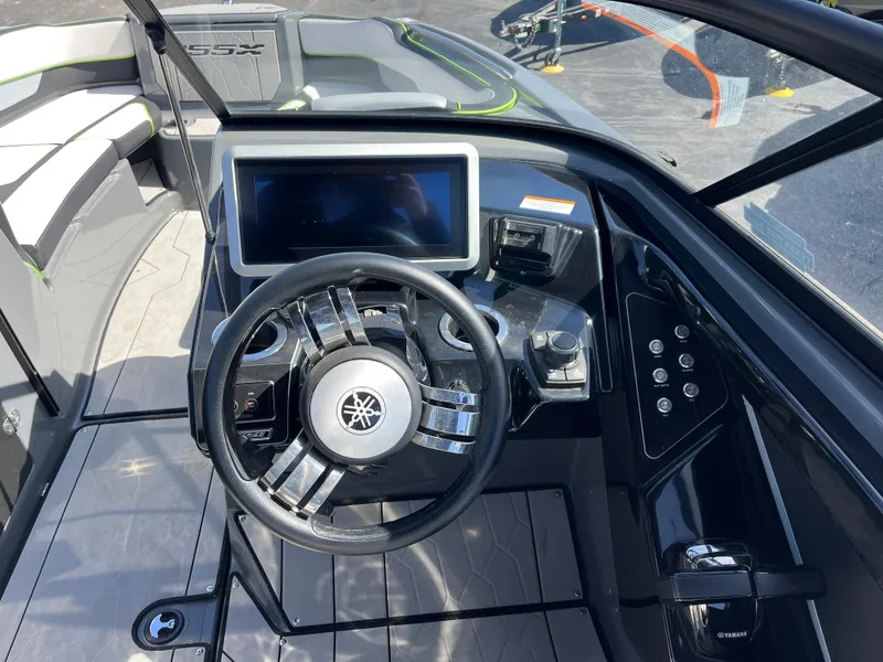 Slide: The Image of 2021 Yamaha Boats 255X dashboard with steering wheel and touchscreen display. - 11