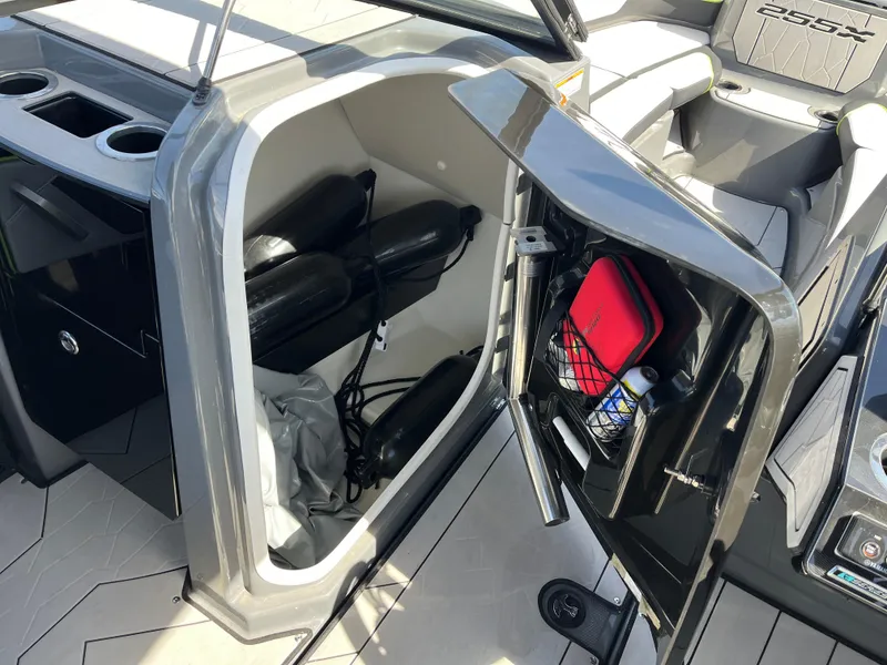 Slide: The Image of 2021 Yamaha Boats 255X storage compartment with safety gear and accessories. - 13
