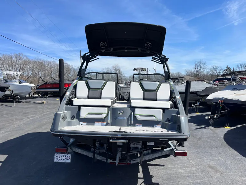 Slide: The Image of 2021 Yamaha Boats 255X, rear view, parked outdoors under clear blue sky. - 4