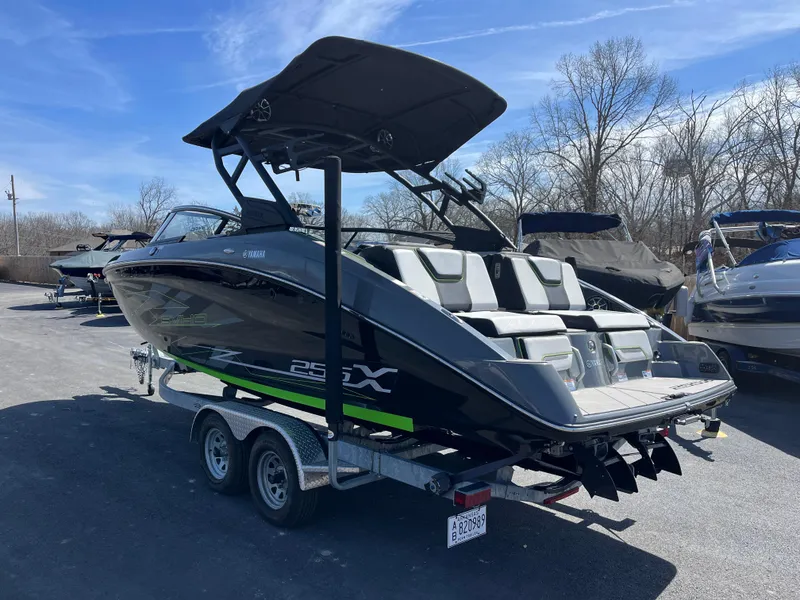 Slide: The Image of 2021 Yamaha Boats 255X on trailer, sleek design, parked outdoors under clear sky. - 5