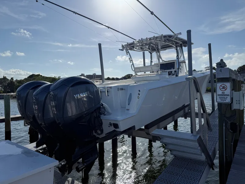 The Image of 2022 Contender 39 ST boat with Yamaha engines on a dock lift. - 0