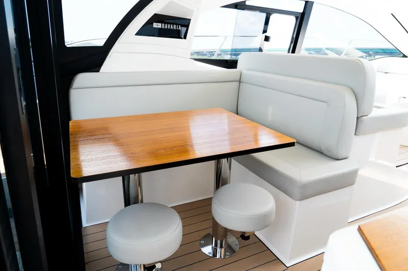 Slide: The Image of Interior of 2022 Bavaria SR41 yacht with wooden table and white seating. - 16