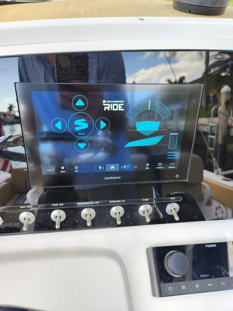 Slide: The Image of 2023 Sportsman Heritage 211 Center Console dashboard with Garmin display and control switches. - 14
