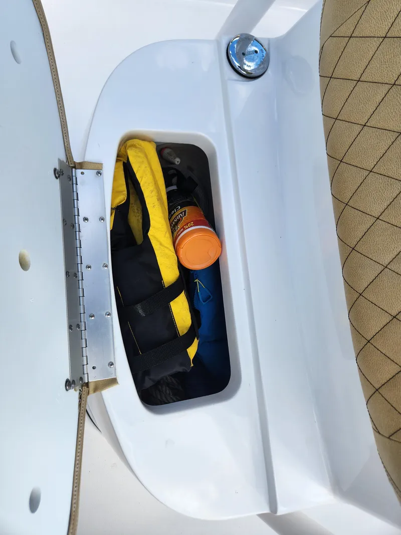 Slide: The Image of Storage compartment in 2023 Sportsman Heritage 211 Center Console boat with life jacket and gear. - 20