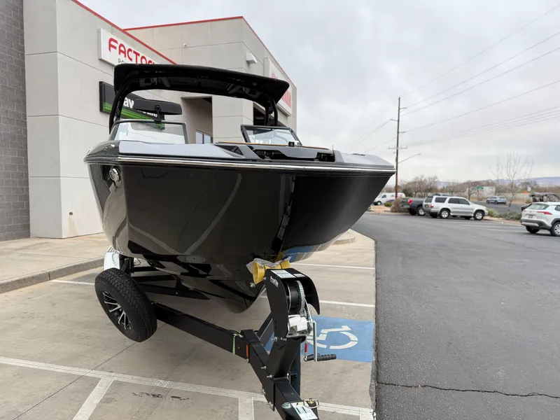 Slide: The Image of 2025 Yamaha Boats 255XD on trailer outside dealership, showcasing sleek black design. - 12