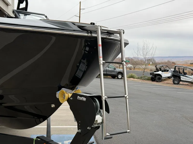 Slide: The Image of 2025 Yamaha Boats 255XD with ladder on trailer in parking lot. - 13