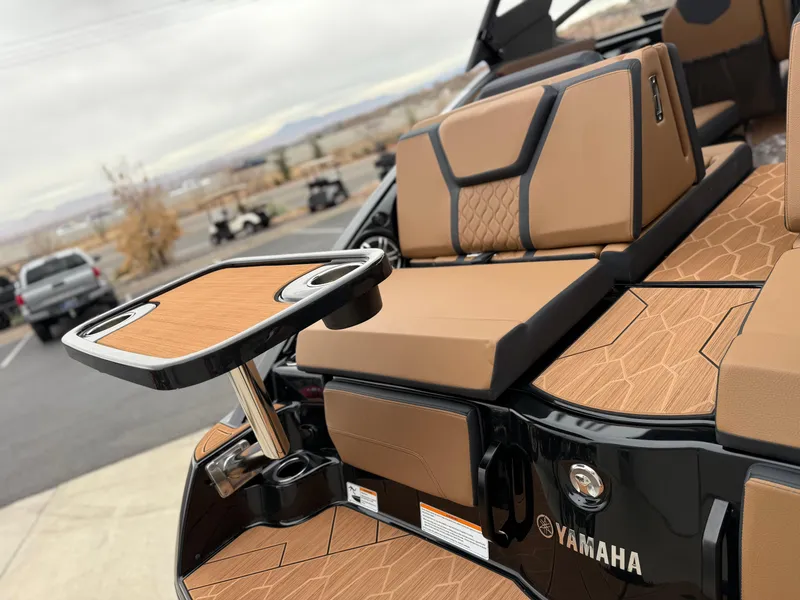 Slide: The Image of 2025 Yamaha Boats 255XD interior with tan seating and a foldable table. - 16