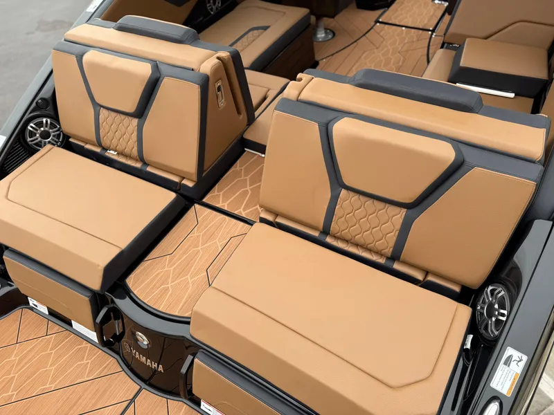 Slide: The Image of 2025 Yamaha Boats 255XD interior with tan and black seating, showcasing modern design and comfort. - 18