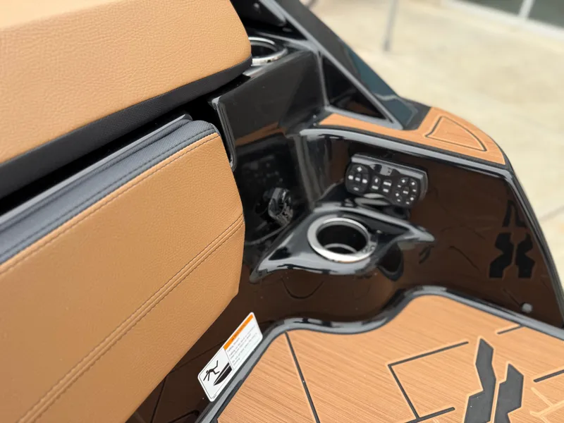 Slide: The Image of Interior of 2025 Yamaha Boats 255XD, featuring tan upholstery and control panel. - 23