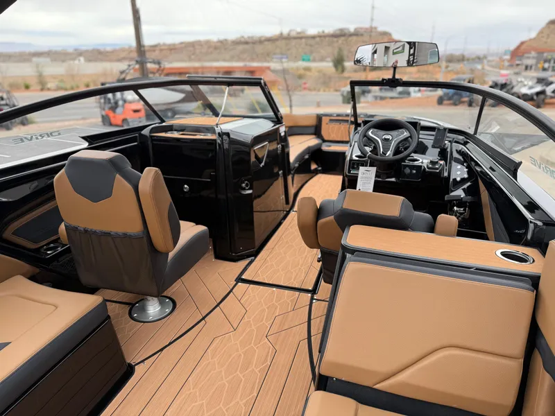 Slide: The Image of 2025 Yamaha Boats 255XD interior with tan and black seating, modern dashboard, and sleek design. - 26