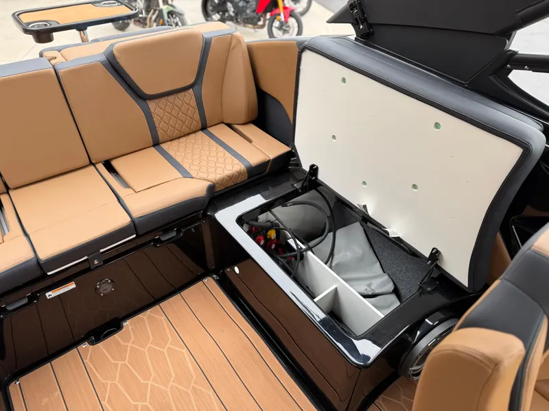 Slide: The Image of 2025 Yamaha Boats 255XD interior with tan seating and open storage compartment. - 36